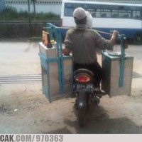 Berkat kemajuan teknologi, pedagang yang satu ini nggak perlu lagi keliling dengan jalan kaki. Biar nggak capai, mending pakai motor aja. Ide bagus bukan? Foto: 1cak.com