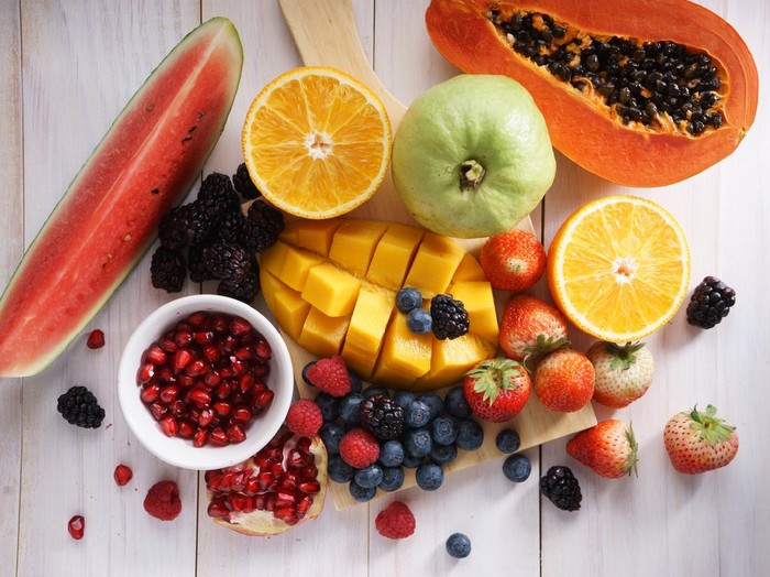 healthy fresh mixed fruits on white wooden table