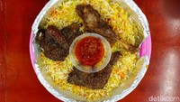 Nasi dari beras basmati ini berwarna kuning oranye, tampak kering dan tidak berminyak. Beberapa rempah tampak masih terlihat, kami bahkan bisa menemukan banyak kapulaga, cengkeh, lada hitam dan potongan kayu manis pada nasinya. Foto: detikFood/Devi S. Lestari