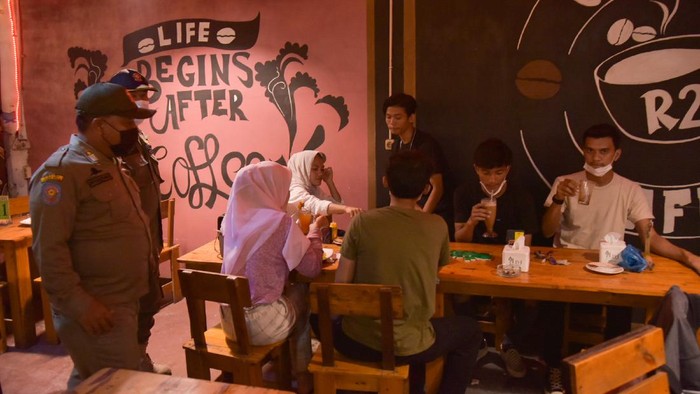 PENYEGELAN RUMAH MAKAN Petugas gabungan dari Kepolisian dan Satpol PP meminta pengunjung dan pemilik usaha kuliner yang melewati batas aturan waktu operasional untuk membubarkan diri saat sidak penerapan Pemberlakuan Pembatasan Kegiatan Masyarakat (PPKM) Mikro di Medan, Sumatera Utara, Jumat (30/6/2021) malam. Tim Patroli Protokol Kesehatan dan PPKM Mikro menyegel warung makan tersebut akibat melanggar Surat Edaran (SE) Wali Kota Medan Bobby Nasution. ANTARA FOTO/Fransisco Carolio/Lmo/wsj.