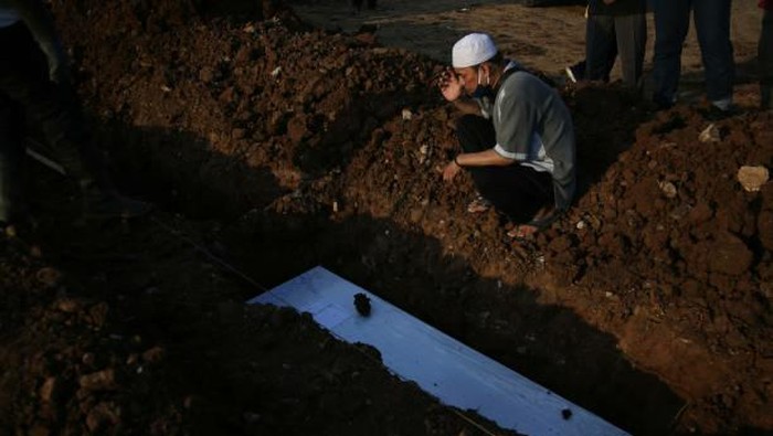 Pilu mendalam di pusara makam COVID-19 Indonesia Saat ini kasus COVID-19 di Indonesia masih terus naik hingga menyentuh 2 juta kasus. Sehingga jenzaha di makam terus berdatangan setiap harinya dan menimbulkan pilu yang mendalam.