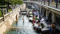 Warga berusaha bermain air untuk kabur dari cuaca panas di taman kota Manezhnaya Square yang tidak jauh dari Lapangan Merah, Moskow (25/6).  Putin mengatakan pada hari Rabu (30/6) bahwa sekitar 23 juta orang Rusia telah menerima vaksin COVID-19. Ia mengatakan vaksin buatan negara itu lebih baik daripada vaksin buatan asing, yaitu AstraZeneca dan Pfizer. Kita baik-baik saja, kata Putin. AP Photo/Alexander Zemlianichenko