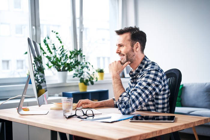 1214341960 Successful freelancer working on computer while staying at home