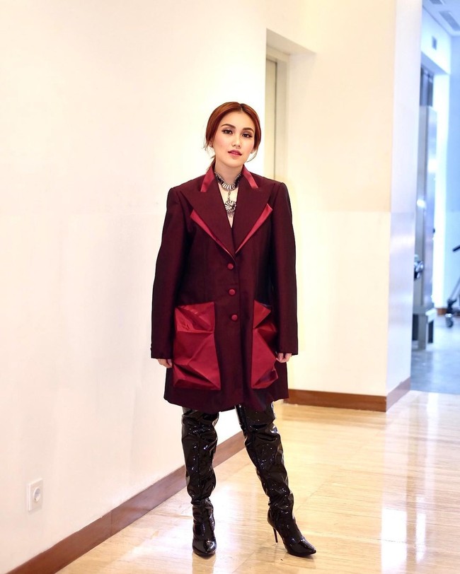 Seperti dalam penampilannya ini. Penampilannya yang satu ini bikin Ayu terlihat seperti sosialita-sosialita di drama Korea. Blazer oversize berwarna merah gelap itu dipadukannya dengan over the knee boots berwarna hitam. Foto: Instagram/@ayutingting92