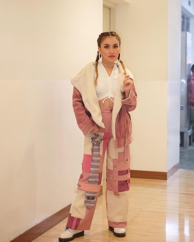 Dengan setelan bernuansa merah muda, Ayu terlihat cantik dan menawan. Untuk bagian dalamnya Ayu memilih mengenakan crop top berwarna putih. Crop top tersebut yang kemudian dipadukan dengan outer dan celana panjang yang bernuansa merah muda. Foto: Instagram/@ayutingting92