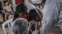 Program vaksinasi COVID-19 massal pun terus digencarkan di berbagai wilayah Indonesia guna menanggulangi pandemi yang tengah melanda Tanah Air. Terbaru, vaksinasi COVID-19 untuk anak usia 12-17 tahun telah dimulai secara bertahap di Indonesia. Pemberian vaksin COVID-19 bagi anak usia 12-17 tahun itu dilakukan usai meningkatnya kasus virus Corona pada anak. Sekitar 12,9 persen kasus COVID-19 adalah kelompok anak usia 0 sampai 18 tahun. Getty Images/Andre Coelho.