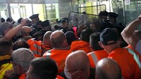 Pengunjukrasa mendorong petugas kepolisian di terminal 2E atau terminal internasional  bandara internasional Charles de Gaulle, Paris (2/7). Para penumpang kebingungan lantaran jadwal penerbangan menjadi tidak terkontrol.  