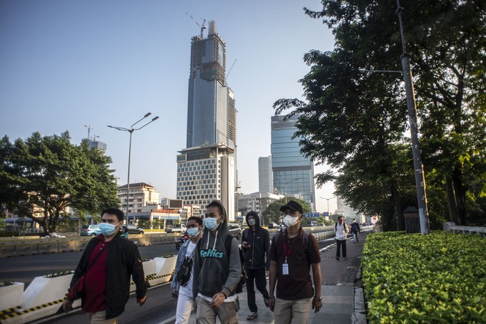 Sejumlah pekerja berjalan di jalur pedestrian Jalan Jenderal Sudirman, Jakarta, Jumat (2/7/2021). Pemerintah akan menerapkan PPKM Darurat di Pulau Jawa dan Bali mulai 3 Juli mendatang, salah satunya mewajibkan menerapkan work from home (WFH) atau bekerja dari rumah 100 persen untuk perkantoran yang bergerak di sektor non-esensial. ANTARA FOTO/Aprillio Akbar/foc.