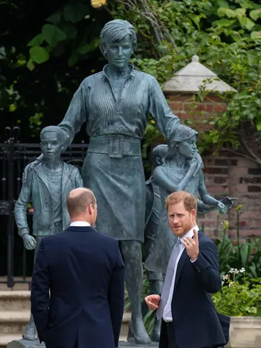 Pangeran Harry dan Pangeran William mengunjungi rumah masa kecil mereka, Istana Kensington. Sebuah patung seorang wanita cantik bersama dua anak terpapang.