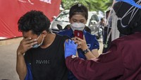 Lelaki ini memilih menutup mata daripada melihat jarum suntik saat vaksinasi massal di Jakarta, Selasa (29/6/2021). Entah takut atau enggan melihat kamera. ANTARA FOTO/Galih Pradipta.