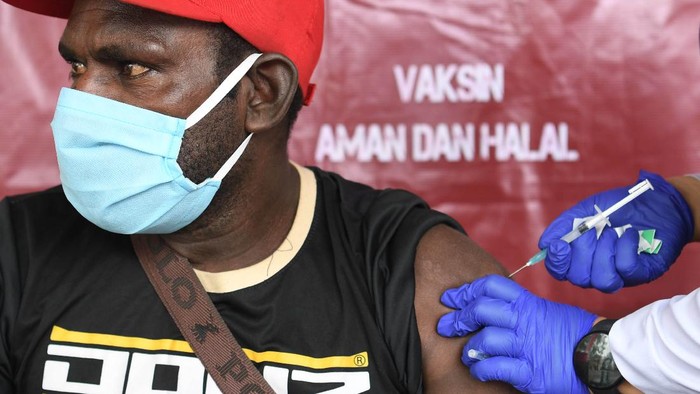 VAKSINASI COVID-19 UNTUK WARGA ASMAT Petugas kesehatan menyuntikkan vaksin COVID-19 kepada warga di Agats, Asmat, Papua, Kamis (1/7/2021). Vaksinasi yang digelar dalam rangka HUT Bhayangkara ke-75 tersebut diperuntukkan bagi warga Agats sebagai upaya guna mempercepat program pemerintah untuk mencapai kekebalan komunal menuju Indonesia sehat bebas COVID-19.ANTARA FOTO/Puspa Perwitasari/aww.