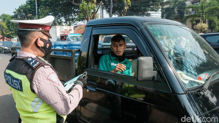 PPKM Darurat mulai diberlakukan hari ini untuk menekan penyebaran COVID-19. Polisi melakukan pemeriksaan di perbatasan dan memantau warga yang tidak bermasker.