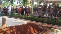 Keluarga Rachmawati terlihat mengikuti prosesi pemakaman lewat tenda kecil yang dibatasi mika. Para pelayat juga hanya bisa menyaksikan pemakaman dari balik pembatas tersebut.