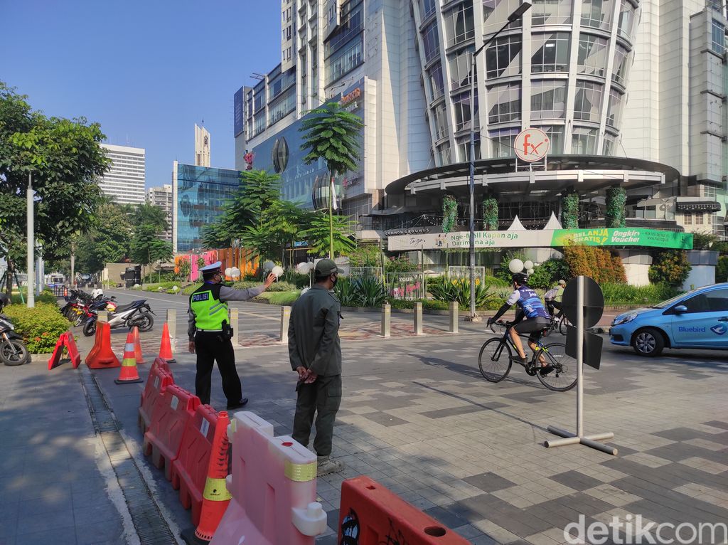 Polisi jalau pesepeda di Jl Jend Sudirman, Senayan, Jakarta, saat PPKM Darurat, 3 Juli 2021. (Azhar Bagas Ramadhan/detikcom)