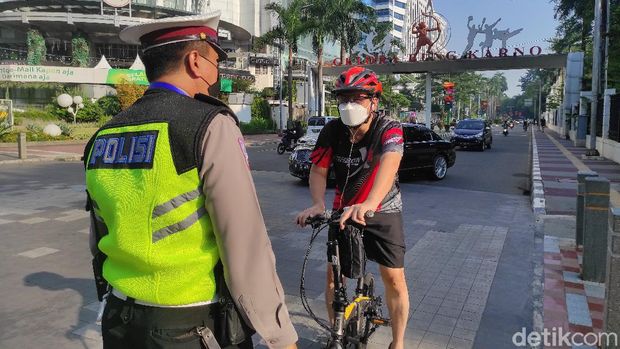 Polisi jalau pesepeda di Jl Jend Sudirman, Senayan, Jakarta, saat PPKM Darurat, 3 Juli 2021. (Azhar Bagas Ramadhan/detikcom)