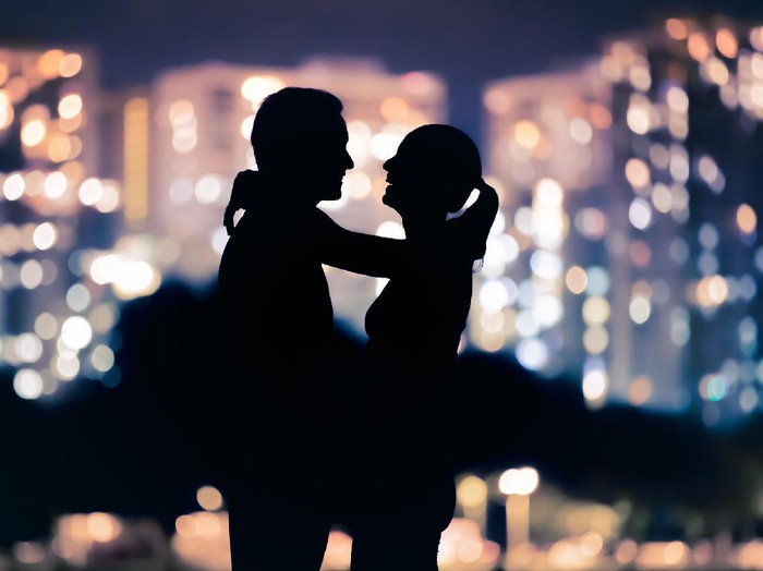 1277539811 Positive young couple sitting at lake shore and making sausages on fire during night camping