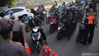 Para petugas memeriksa para pengendara motor maupun mobil yang hendak masuk ke kawasan Ibu Kota. 