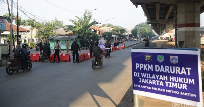Sejumlah petugas memeriksa pengendara motor dan mobil di pos penyekatan Kalimalang, Jakarta. Pemeriksaan dilakukan sebagai bagian dari penerapan PPKM Darurat.