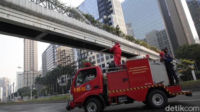 Penyemprotan disinfektan dilakukan di kawasan Jalan Jenderal Sudirman, Jakarta. Kegiatan itu dilakukan sebagai upaya pencegahan penyebaran virus Corona.