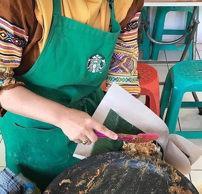 Celemek dapur si ibu yang satu ini logonya mirip merek tempat kopi ternama ya? Mungkin sebelumnya si ibu pernah bekerja di sana. Foto: Instagram/@katalucugambar