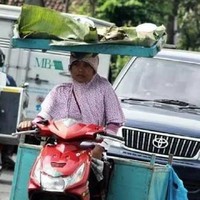 Dari foto ini terbukti bahwa emak-emak memang jago banget multitasking. Lihat saja emak yang satu ini, bisa naik motor sambil bawa barang di kepalanya. Foto: 1cak.com