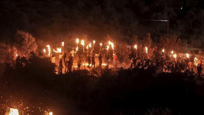 Palestinian protesters gather with torches during a demonstration against the Israeli settlers outpost of Eviatar, in the town of Beita, near the occupied West Bank city of Nablus, on July 3, 2021. (Photo by JAAFAR ASHTIYEH / AFP)