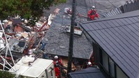 Petugas menyisir rumah warga yang terdampak longsor untuk mencari dan mengevakuasi korban. Kyodo News via AP