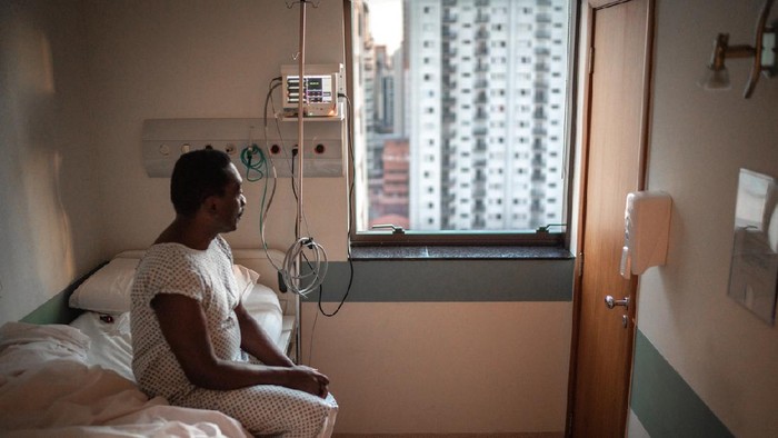 In the Hospital Sick Male Patient Sleeps on the Bed. Heart Rate Monitor Equipment is on His Finger.