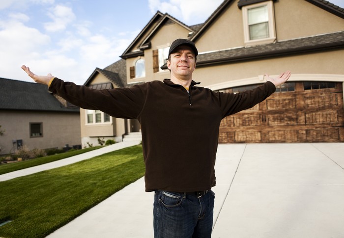 184107089 Man standing in front of his new home.