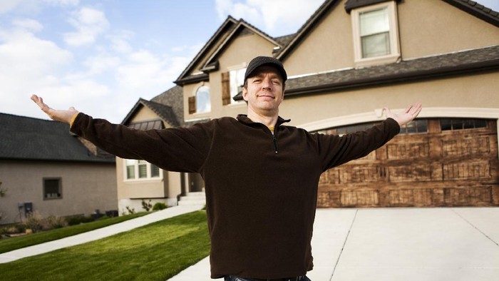 184107089 Man standing in front of his new home.