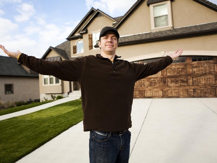 184107089 Man standing in front of his new home.