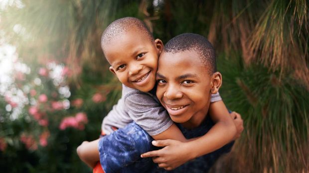 Portrait of two happy boys enjoying a piggyback ride outdoors
