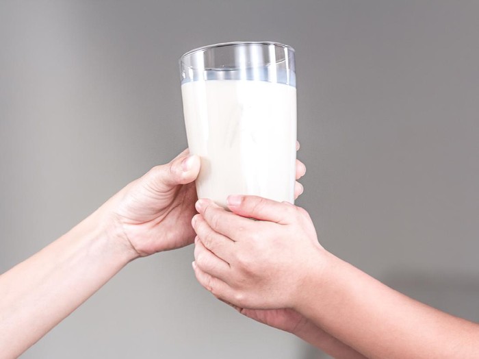 Mother and child holding a glass of milk