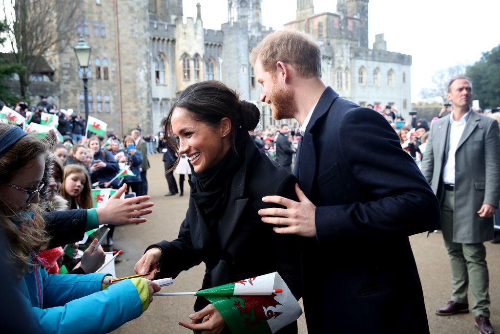 CARDIFF, WALES - JANUARY 18:  Prince Harry and his fiancee Meghan Markle sign autographs and shake hands with children as they arrive to a walkabout at Cardiff Castle on January 18, 2018 in Cardiff, Wales.  (Photo by Chris Jackson/Getty Images)