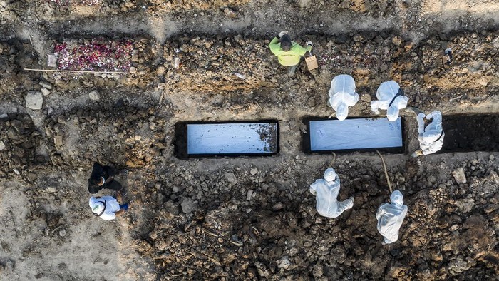 Petugas makam Petugas memakamkan jenazah dengan protokol COVID-19 di TPU Rorotan, Cilincing, Jakarta, Minggu (4/7/2021). Jumlah kematian akibat COVID-19 per hari Minggu (4/7/2021) mencapai 555 kasus, yang menjadi rekor tertinggi sejak kasus pertama COVID-19 di Indonesia diumumkan Presiden Joko Widodo pada awal Maret 2020. ANTARA FOTO/Muhammad Adimaja/aww.