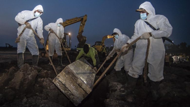 Petugas makam Petugas memakamkan jenazah dengan protokol COVID-19 di TPU Rorotan, Cilincing, Jakarta, Minggu (4/7/2021). Jumlah kematian akibat COVID-19 per hari Minggu (4/7/2021) mencapai 555 kasus, yang menjadi rekor tertinggi sejak kasus pertama COVID-19 di Indonesia diumumkan Presiden Joko Widodo pada awal Maret 2020. ANTARA FOTO/Muhammad Adimaja/aww.