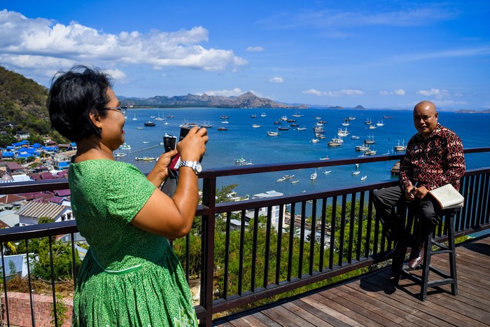 Wisatawan melihat komodo di Taman Nasional Komodo, Nusa Tenggara Timur.