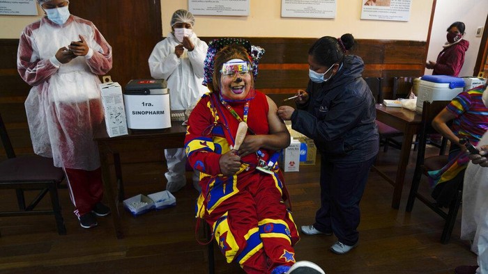 A clown gets a shot of the Sinopharm COVID-19 vaccine during a vaccination campaign targeting people between ages 18 and 30 at the public University San Andres in La Paz, Bolivia, Monday, July 5, 2021. (AP Photo/Juan Karita)