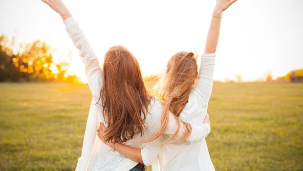 Young women are having fun on the green field in the evening.