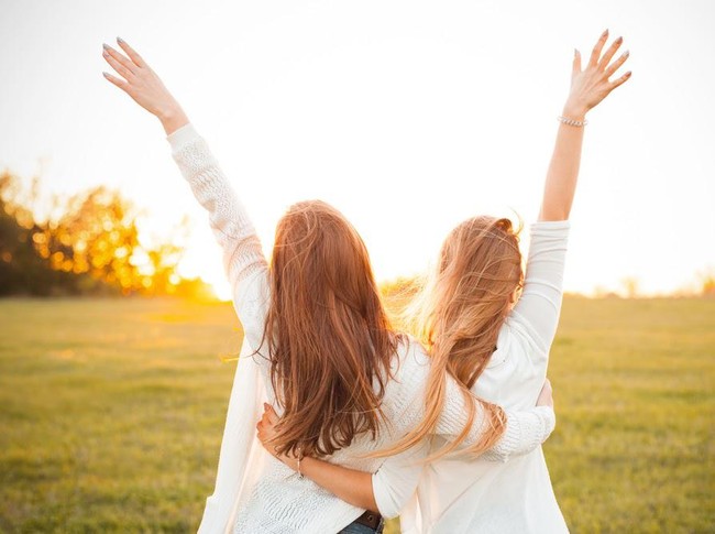 Young women are having fun on the green field in the evening.