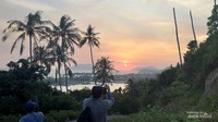 Seorang wisatawan luar negeri sedang menikmati matahari terbenam disalah satu sudut pulau.