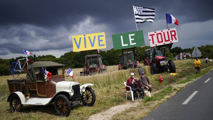 A spectator waits for the pack during the first stage of the Tour de France cycling race over 197.8 kilometers (122.9 miles) with start in Brest and finish in Landerneau, France, Saturday, June 26, 2021. (AP Photo/Daniel Cole)