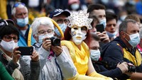 Pentonon mengenakan topeng saat menanti pebalap melintas di garis finis di etape ke empat TDF 2021 (29/6). (Benoit Tessier/Pool Photo via AP)