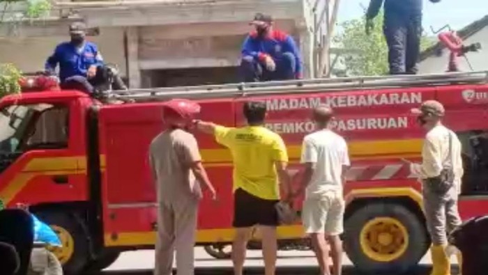 Seorang pria ngamuk ke petugas BPBD Kota Pasuruan yang melakukan penyemprotan disinfektan, dengan mobil pemadam kebakaran. Pria itu membawa batu besar sambil memarahi petugas.
