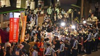 Masyarakat saat berunjukrasa di depan Balai Kota Tokyo, (23/6) untuk memprotes penyelenggaraan olimpiade. (AP Photo/Eugene Hoshiko)