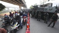 Sejumlah prajurit TNI berjaga di area penyekatan yang berada di salah satu ruas jalan di Ibu Kota Jakarta, Senin (5/7/2021). Kendaraan taktis tampak dikerahkan untuk mengadang kendaraan yang hendak masuk ke Jakarta di kala pemberlakuan PPKM Darurat.