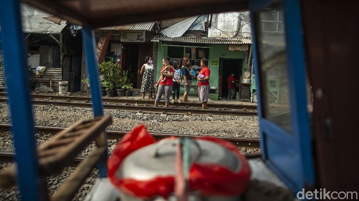 Warga ramai-ramai berjemur di bawah sinar matahari pagi untuk memperkuat sistem imun. Selain di tanah lapang, warga juga berjemur di jalur perlintasan kereta api di Jakarta.
