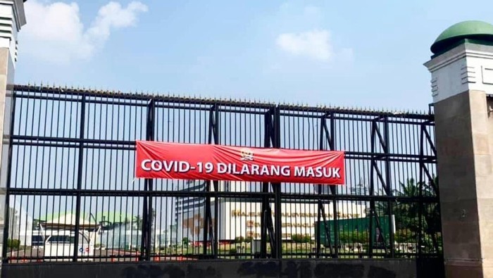 Spanduk COVID-19 Dilarang Masuk dipasang di gerbang utama komples DPR, Jakarta, Rabu (7/7/2021).
