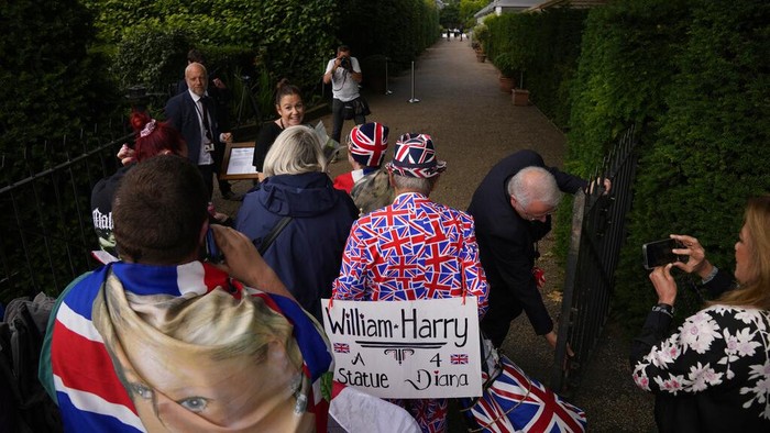 The gates are opened to allow people to see the statue of Diana, Princess of Wales, a day after its unveiling, in the Sunken Garden at Kensington Palace, London, Friday July 2, 2021. The statue, which shows a larger-than-life Diana surrounded by three children, was commissioned by Prince William and Prince Harry in 2017.