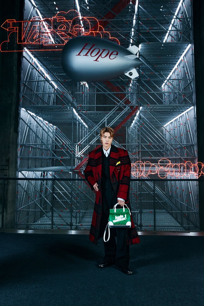 Setelah Jungkook, ada Jin BTS yang memegang koleksi tas hijau Litter Bag. Pemilik nama asli Kim Seokjin itu menutup gelaran fashion show Louis Vuitton, dalam balutan coat merah dengan corak hitam. Foto: dok. Louis Vuitton